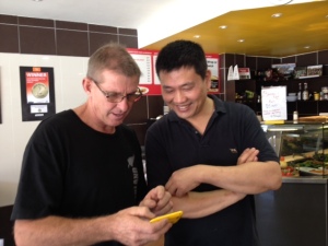 Pete showing James from Chicken Run in Dee Why photos on his phone.